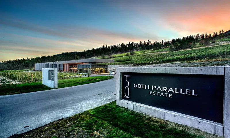 50th Parallel Estate sign at sunset